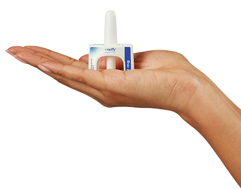 Hand extended holding neffy intranasal device in palm of hand